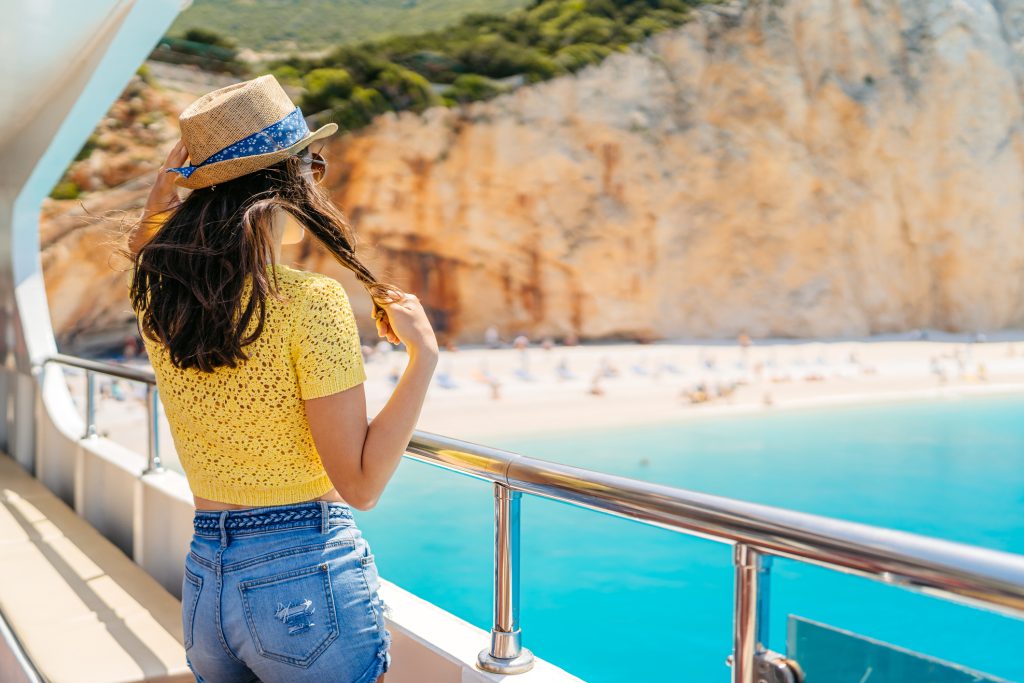 Young woman looking at view of the Porto katsiki beach from the boat in Parga in Greece